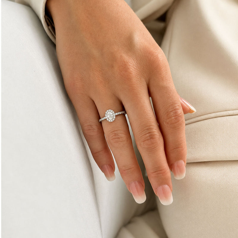 Platinum and Oval Cut Diamond Halo Ring With Round Brilliant Diamond Shoulders