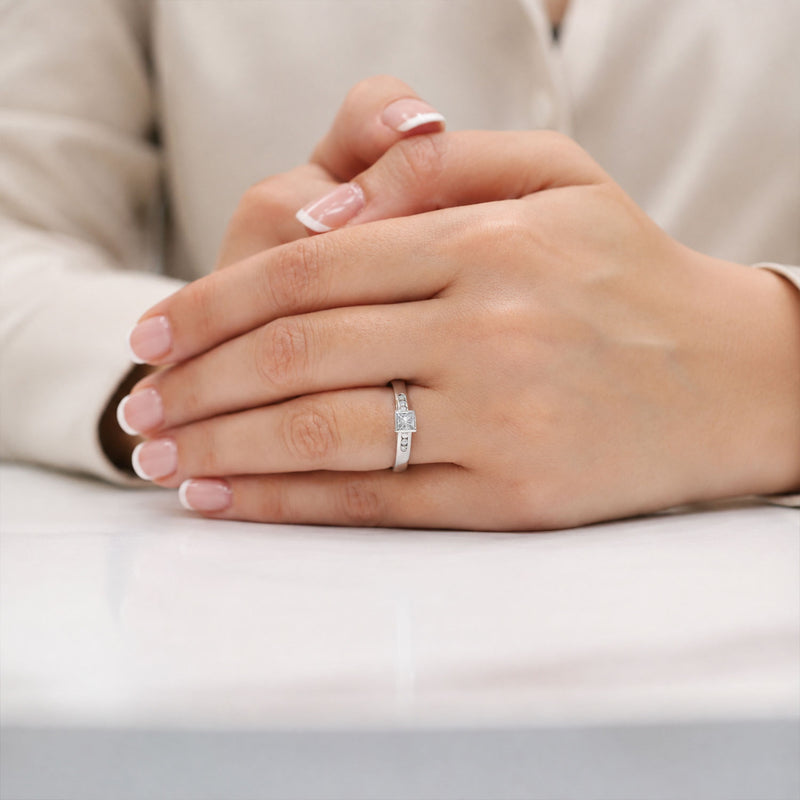 18ct White Gold Princess Cut Diamond Rub Over Set Solitaire Ring With Round Brilliant Cut Channel Set Diamond Shoulders