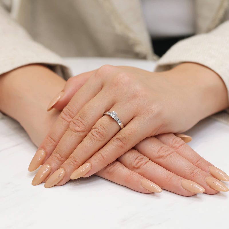 Berry's 18ct White Gold Princess Cut Diamond Rub Over Set Solitaire Ring With Round Brilliant Cut Channel Set Diamond Shoulders - Berry's Jewellers