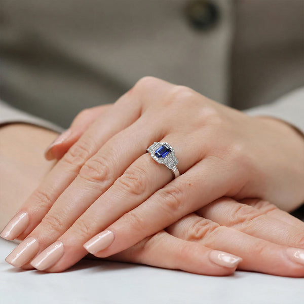 Platinum Sapphire And Baguette Cut Diamond Three Stone Ring With A Halo Surround
